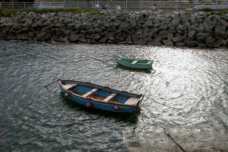 two small blue boats sitting in the middle of the water