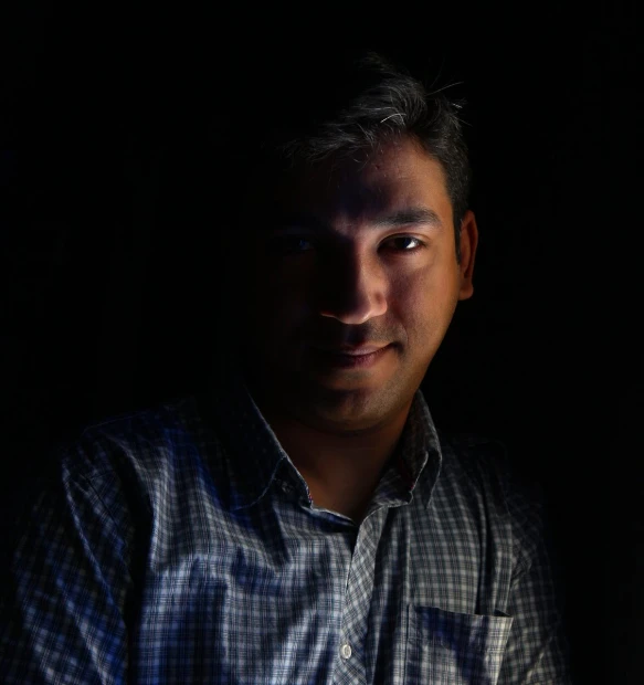 a man in the dark with a dark background
