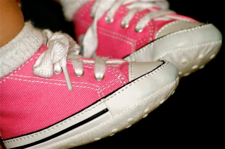 a pair of pink converse sneakers with white laces