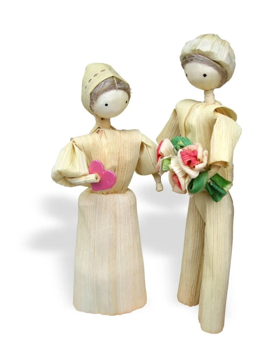 two wooden dolls, each holding bouquets and a heart