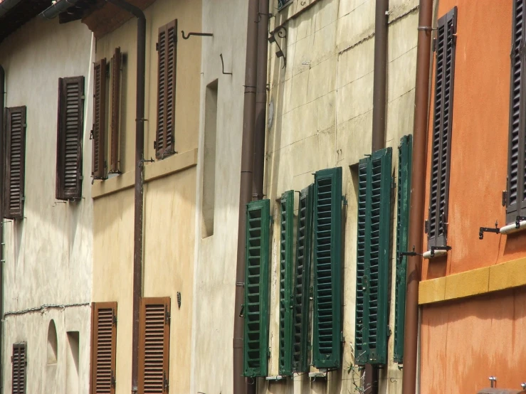 three buildings with windows that have closed and shutters