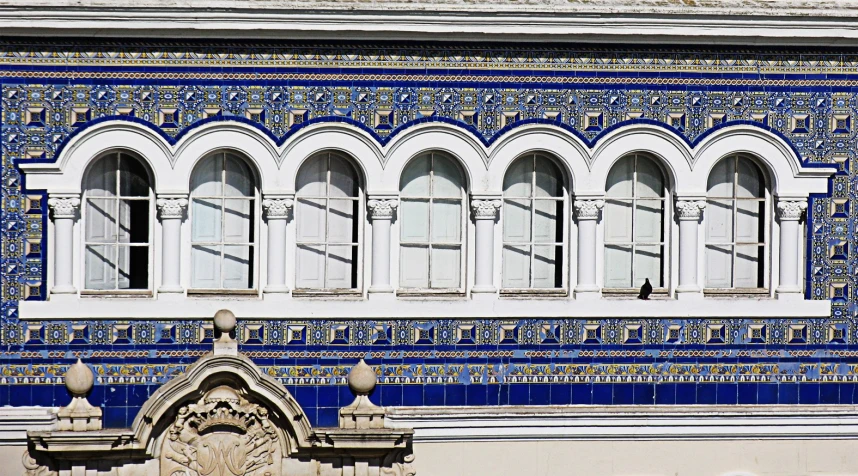 a building with four arched windows has blue and white painted on it