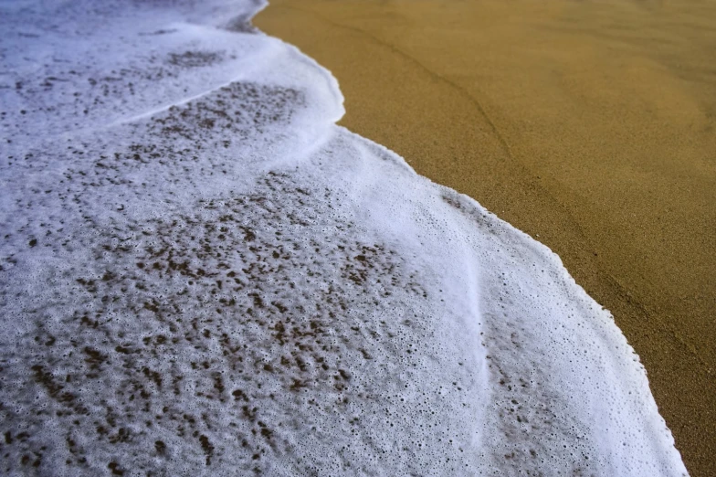 some white foam and a brown wet ocean