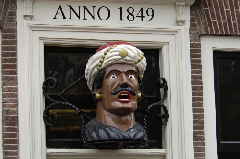 a statue of a man sticking his head out of a window