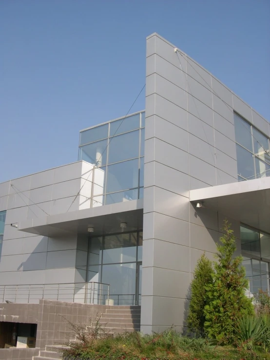 a large grey building with a balcony on the top floor