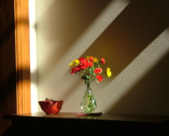 a glass vase filled with red and yellow flowers