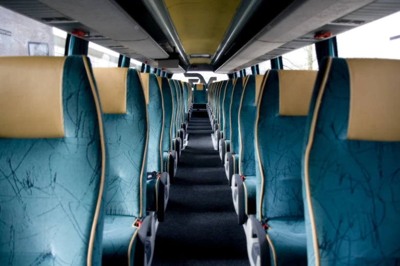 the inside of an empty bus with blue seats and yellow trims