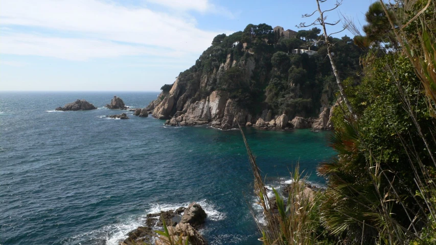 a very large body of water next to a lush green hillside