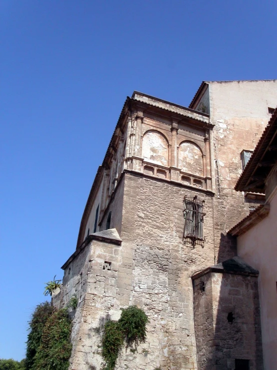 the front of a stone building has many windows and is partially visible