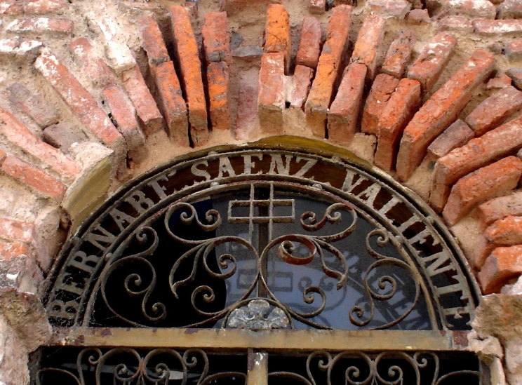 an iron gate on a brick wall and a stone arch