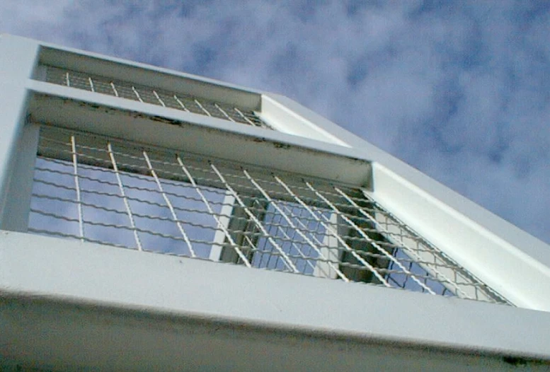 a window and railing outside under the blue sky