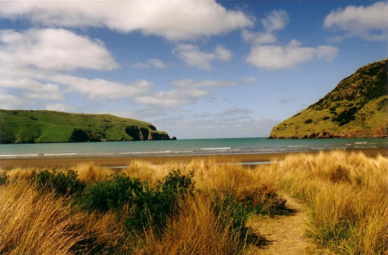 the ocean has mountains and sand near it