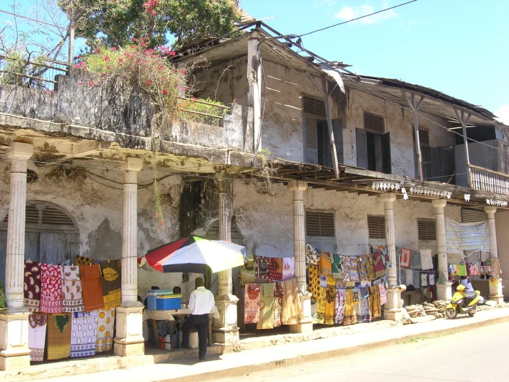 a man standing outside of an abandoned building with an umbrella