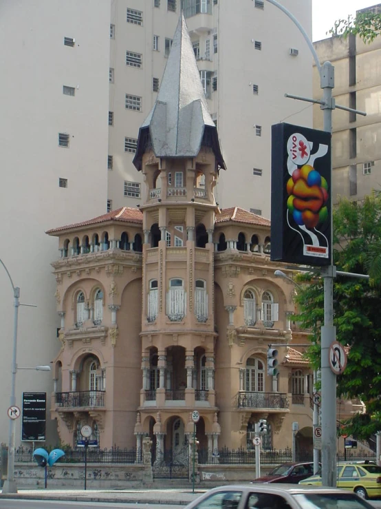 a tall brown building with lots of windows next to a street