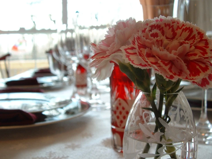 some pink flowers are in the vase on a table