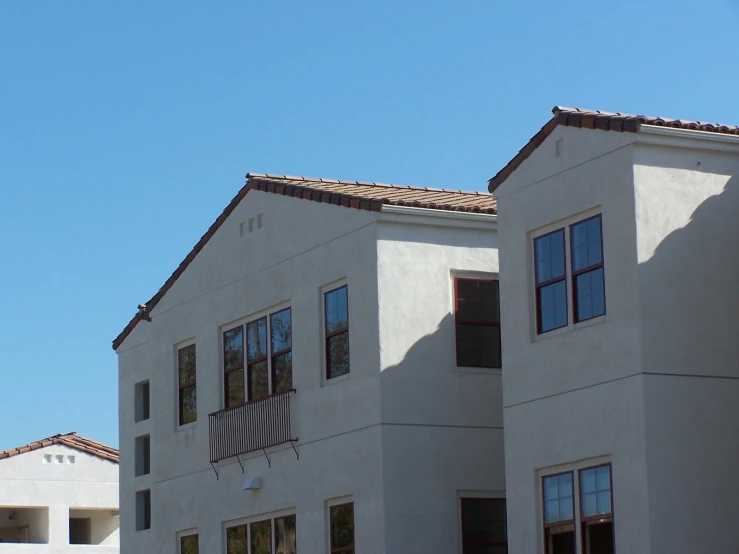 a building has two story buildings with one of the buildings painted white