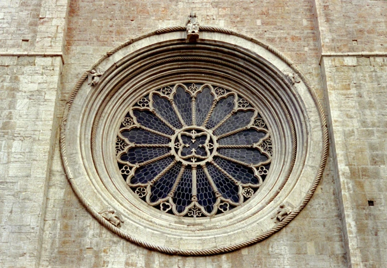 an artistic and highly decorative window is shown on a stone wall