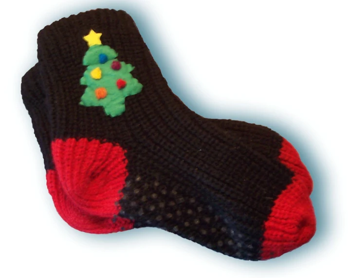 a knit christmas tree is displayed on a pair of socks