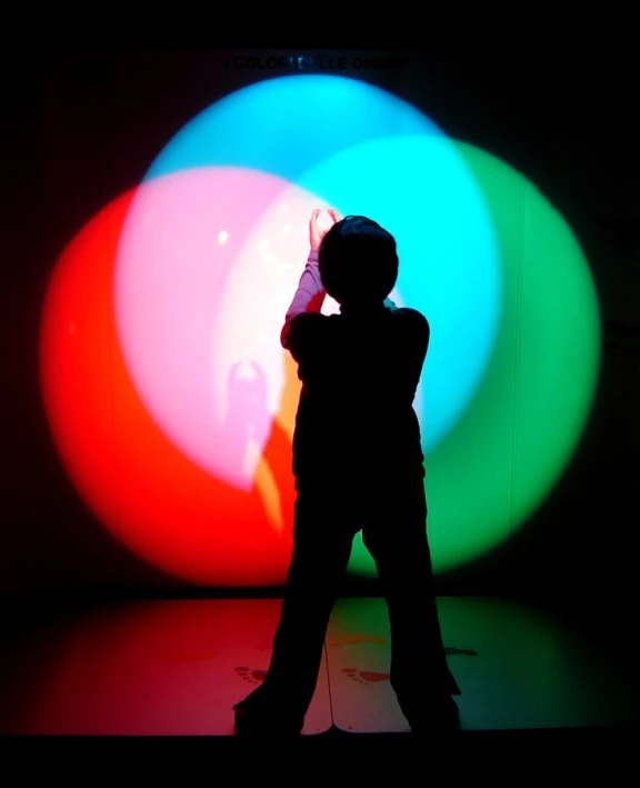 a child in front of a brightly colored light