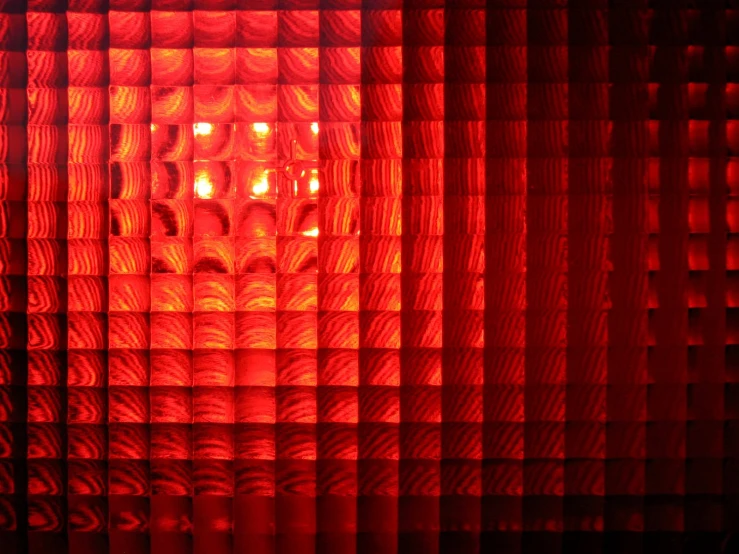 a large multi - colored wall is behind a red curtain