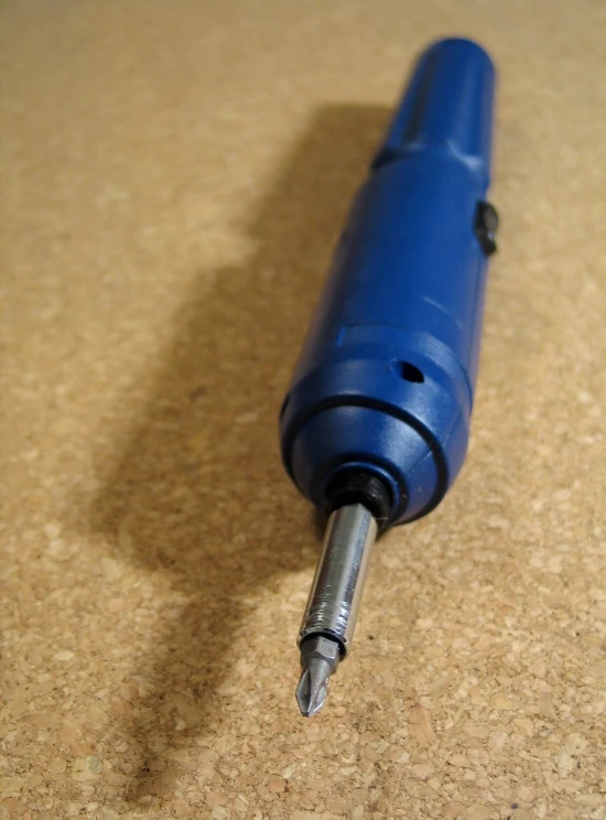 a blue pen sitting on a brown surface