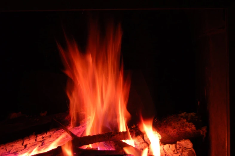 a fire is blazing in a burning fireplace