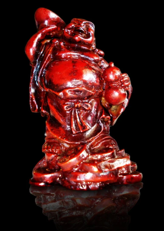 red glass sculpture depicting a person holding an apple