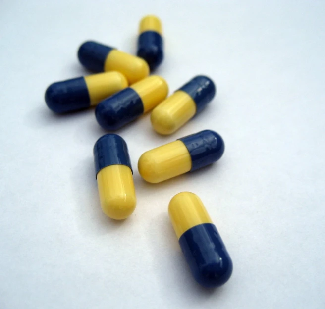 some blue and yellow pills sit on the table