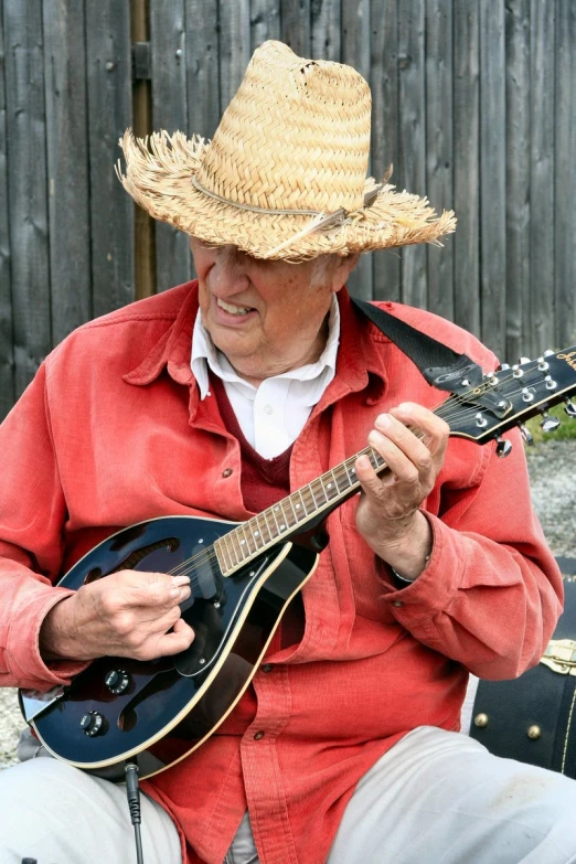 the man is playing the guitar in the street