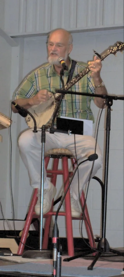 a man that is sitting in a chair with a guitar