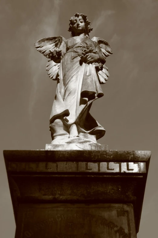 a black and white image of a statue of a woman with wings