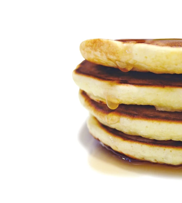 a stack of pancakes with syrup being poured on them