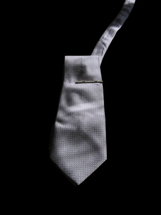 a white tie with a single silver on on it