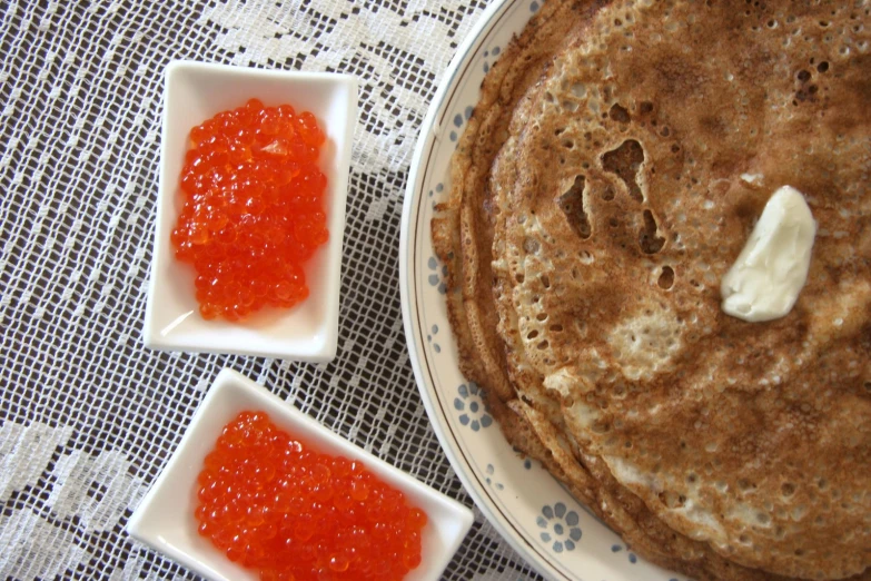 two plates with pancakes and sauces on them