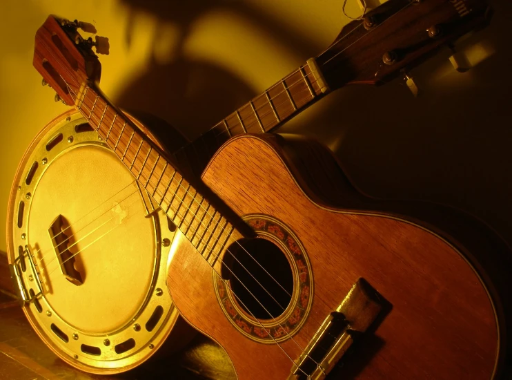 an acoustic guitar sits on a counter with an electric device beside it