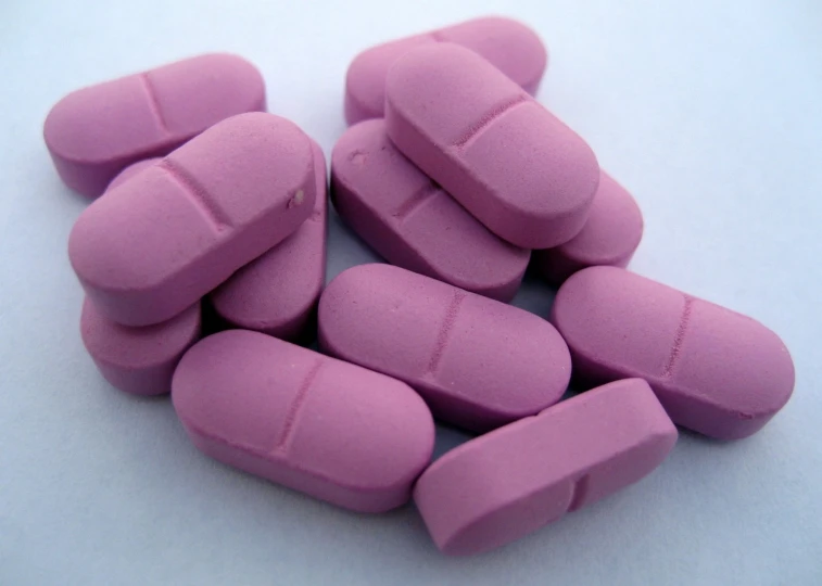 several pink pills are sitting out on the table