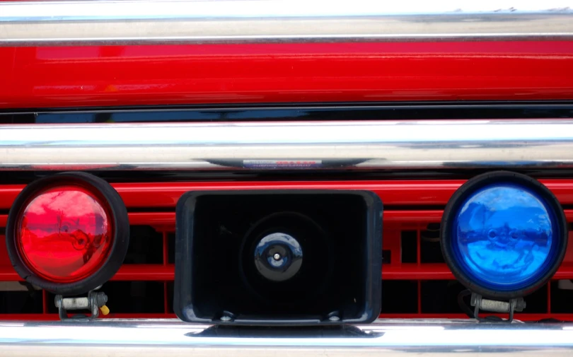 the front end of an old red fire truck with blue lights on