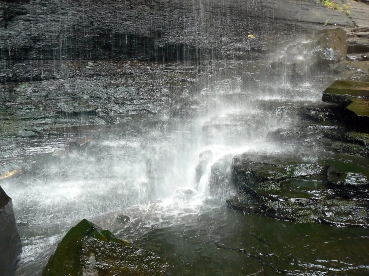 a waterfall being gused water with a red fire hydrant nearby