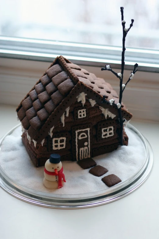 a cake decorated with a house and man on top of a plate