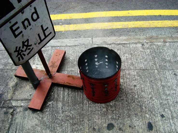 a street sign and red and black container