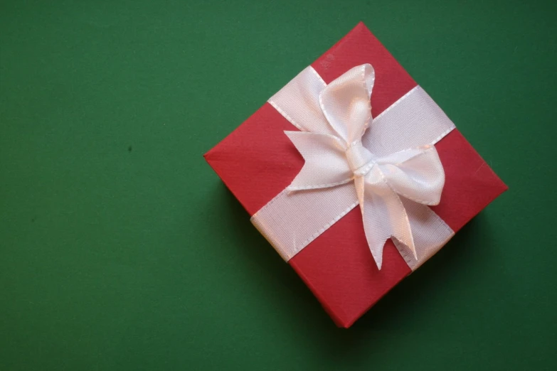 a red wrapped gift with white ribbons