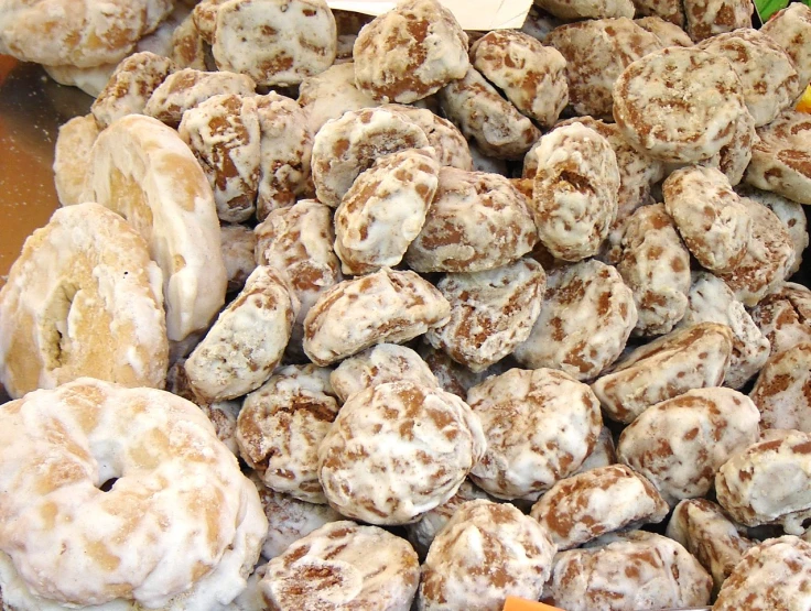 a pile of powdered donuts sitting in front of a glass container