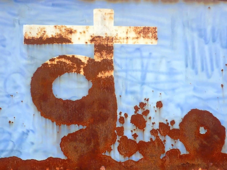 a rusty metal cross and a hole in the top