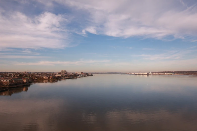 a beautiful blue sky hangs over the large body of water