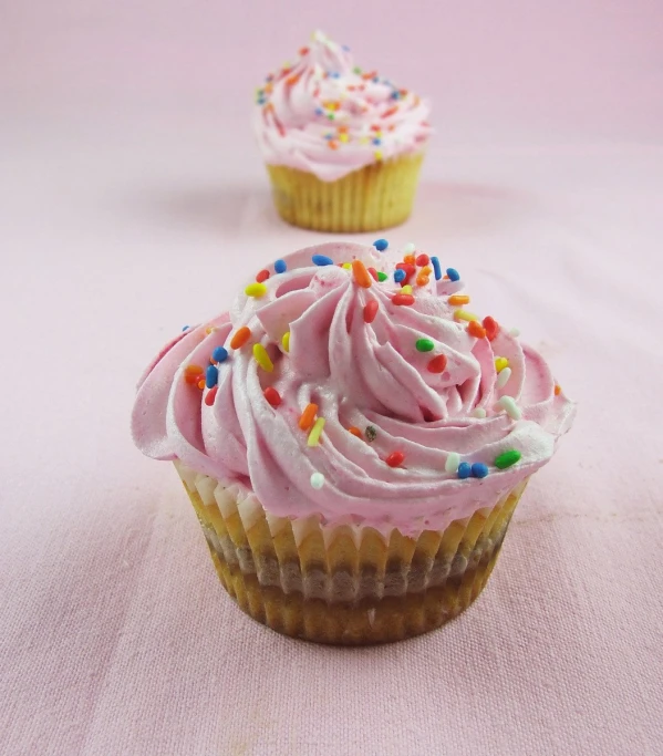 pink frosted cupcake on a light pink background