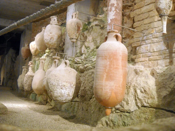 a bunch of stone bottles hang up on a rope