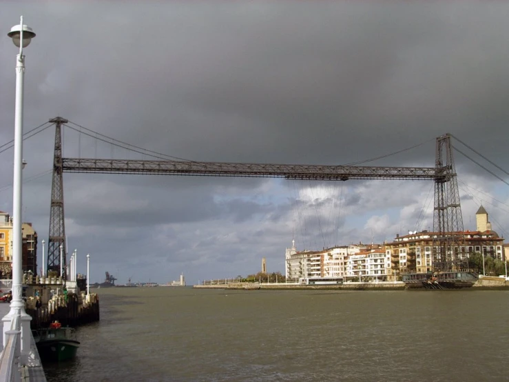 a bridge is above a river with clouds in the background