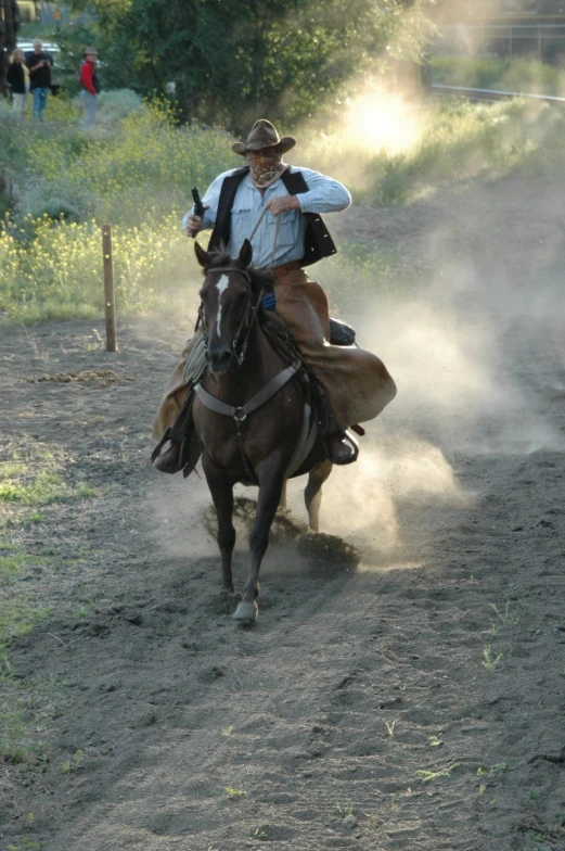 a man on a horse riding on the dirt