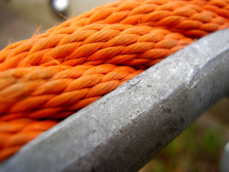 an orange rope is next to a metal pole