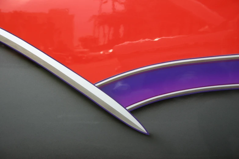 a curved red and purple sign on the front of a vehicle